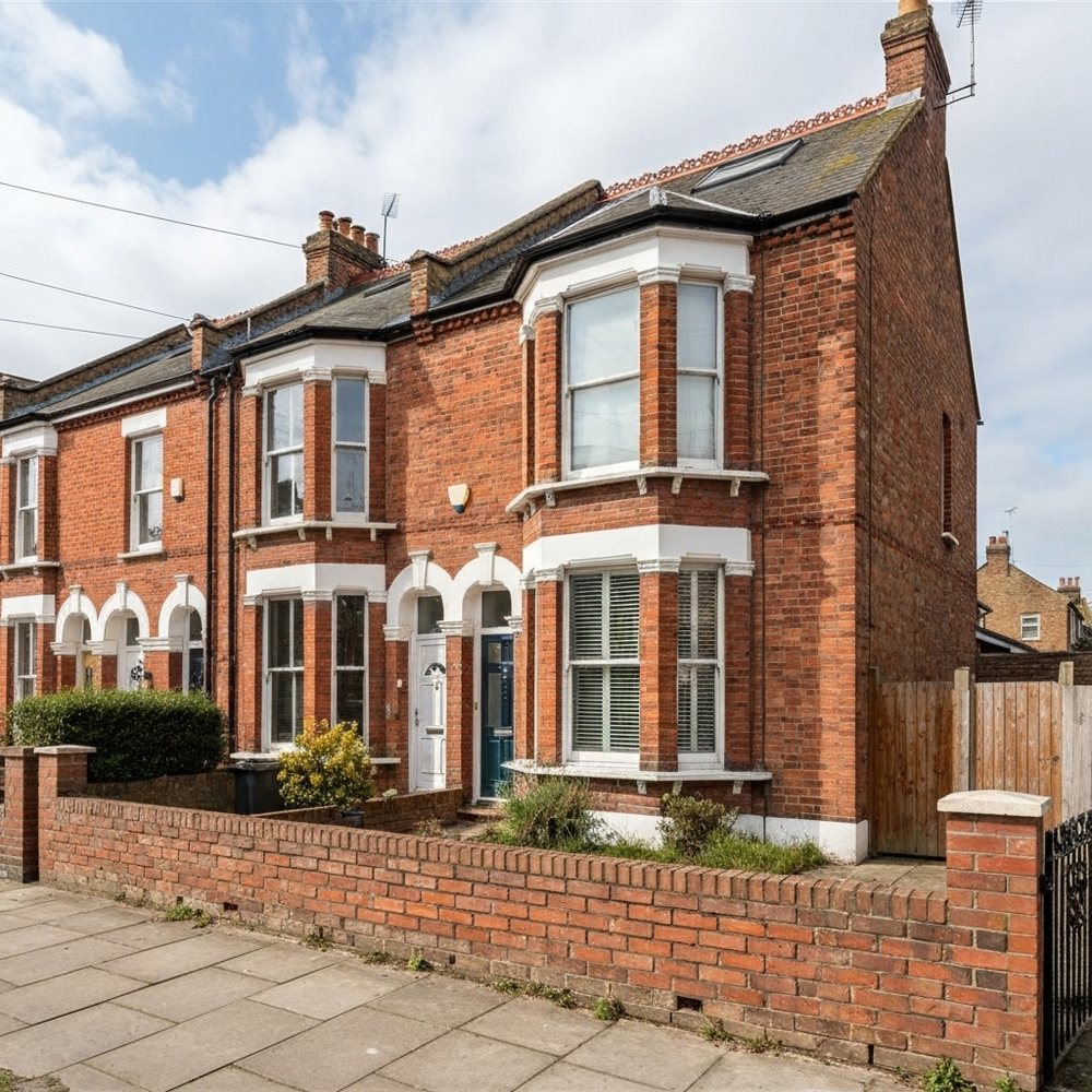 Red-brick period family home with bay windows and a small front garden